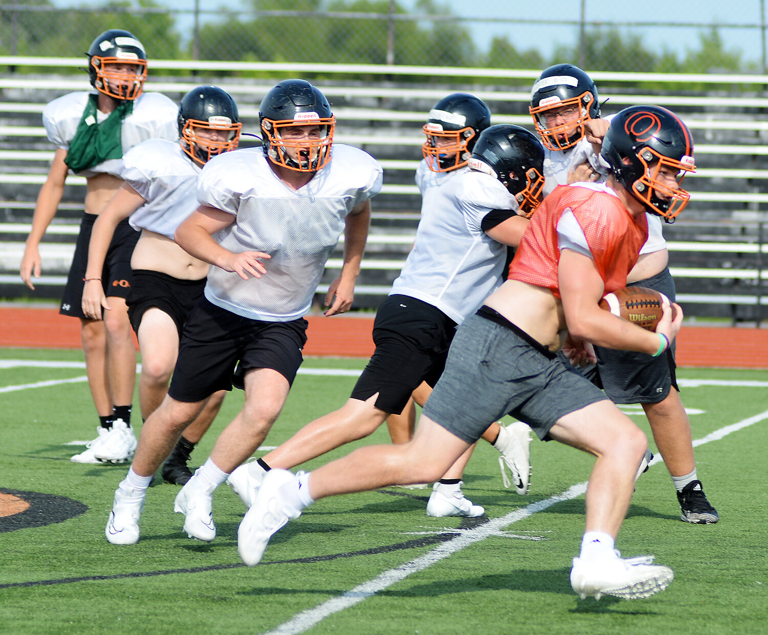 Blake Elliott (far right) locates a hole in the defense during a recent practice session last week for Owensville Dutchmen football at Dutchmen Field. Now a senior, Elliott will lead the Dutchmen beginning this Friday by hosting their first-ever preseason jamboree beginning at 6 p.m. Teams competing along with the host orange and black include Linn’s Wildcats, Fulton’s Hornets, Hermann’s Bearcats, Montgomery County’s Wildcats and Russellville’s Indians. First-year Dutchmen head football coach Dustin Howard will make his head-coaching debut on Friday, Aug. 25 in a Highway 19 showdown on the road  at Cuba High School against the host Wildcats with a 7 p.m., kickoff. Dutchmen fans will have to wait until Friday, Sept. 8 to see the orange and black at Dutchmen Field in their home opener against Warrenton’s Warriors.
